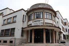 Entrada principal del espacio NORMAL con arquitectura moderna y columnas