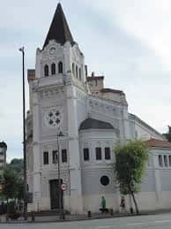 Fachada principal de la Parroquia de Nuestra Señora de la Medalla Milagrosa en Bilbao, con torre y reloj