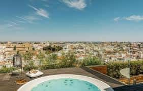 Terraza con jacuzzi y vista panorámica de Sevilla bajo cielo despejado
