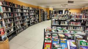Interior de la biblioteca con estanterías de libros y zona de lectura