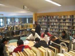 Usuarios leyendo en mesas dentro de la biblioteca
