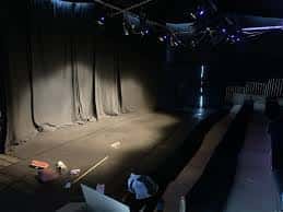 Interior del auditorio del teatro con escenario y cortinas cerradas