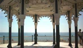 Interior del pabellón con columnas decoradas y vista panorámica del océano desde la plataforma