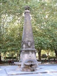 Detalle del obelisco y la fuente en la Plaza de Recoletas con árboles al fondo
