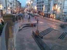 Plaza del Farolón en Vitoria al atardecer con iluminación urbana y peatones