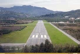 Vista aérea de la pista de aterrizaje del aeródromo con montañas al fondo