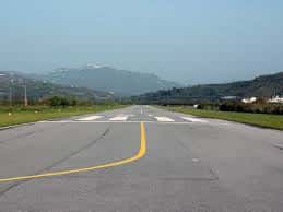Pista de aterrizaje del aeródromo con líneas amarillas y paisaje montañoso