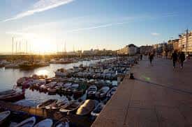 Muelle del Puerto de Santander al atardecer con embarcaciones y paseo marítimo