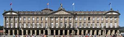Vista panorámica frontal del Concello de Santiago de Compostela con fachada neoclásica y banderas