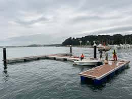 Muelle flotante con elementos de amarre y embarcaciones en el puerto