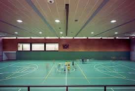 Interior del pabellón mostrando la cancha deportiva y el techo con iluminación integrada
