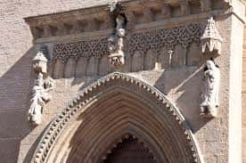 Detalle arquitectónico del arco de entrada con esculturas y decoración gótica