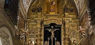 Detalle del retablo mayor con la imagen del Crucificado y decoración barroca dorada