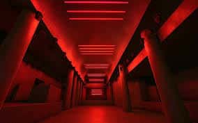 Interior del club Quarters con pasillo iluminado en rojo y columnas estructurales
