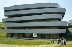 Vista exterior del Basque Culinary Center con su característica arquitectura curvilínea y fachada de hormigón