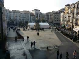 Plaza de la Virgen Blanca con estructura de evento montada y público caminando