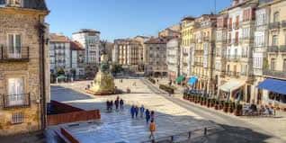 Plaza de la Virgen Blanca desde una perspectiva elevada con edificios históricos y gente paseando