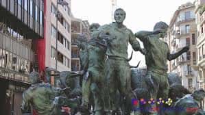 Monumento de bronce con figuras humanas y animales en la plaza