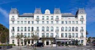Vista frontal del Gran Hotel Sardinero con fachada blanca y detalles arquitectónicos clásicos bajo cielo azul