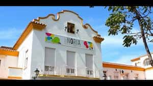Fachada exterior del edificio La Noria con su distintivo logo y arquitectura tradicional