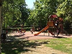 Zona de juegos infantiles con tobogán y estructuras de madera