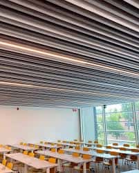 Sala de conferencias con techo de listones y mesas dispuestas