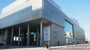 Vista exterior del edificio moderno de la UNED Vigo con fachada de cristal y columnas
