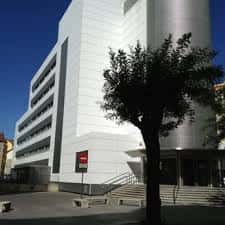 Vista exterior del Ambulatorio de Olaguibel con fachada moderna y árbol en primer plano