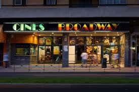 Fachada nocturna de los Cines Broadway con letrero iluminado