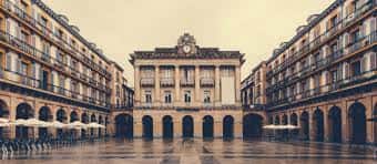 Plaza Gipuzkoa en San Sebastián con arquitectura clásica y arcos bajo luz suave