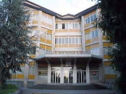 Entrada principal del edificio con letrero del nombre del colegio