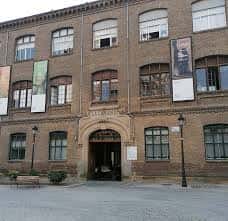 Fachada histórica del edificio de la calle Segismundo Moret con detalles arquitectónicos y banderines
