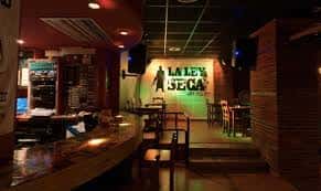 Interior de la sala La Ley Seca mostrando el bar y el escenario con el logo iluminado