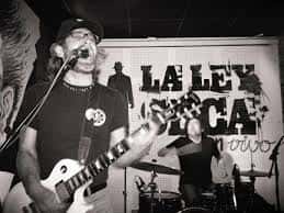 Músico tocando la guitarra en el escenario de La Ley Seca durante un concierto