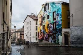 Calle Correría en Vitoria con un mural colorido en la fachada de un edificio