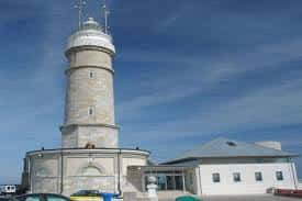 Vista exterior del Faro de Cabo Mayor y su anexo moderno bajo cielo azul