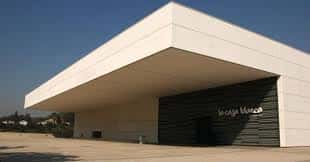 Vista exterior del Auditorio La Caja Blanca con su distintiva fachada blanca y entrada oscura