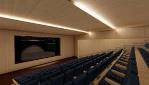 Interior del auditorio con butacas azules y escenario iluminado
