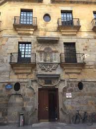 Vista frontal del Palacio John (La Bolsa) mostrando su fachada histórica de piedra y balcones