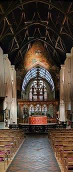 Interior de la nave principal con bóveda de madera, vitrales y altar central decorado