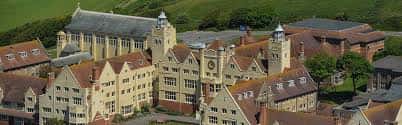 Vista aérea del campus de Roedean School con sus edificios históricos de ladrillo y tejados grises, rodeado de zonas verdes