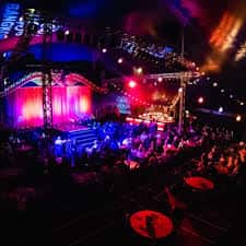 Interior del Sabai Pavilion con escenario iluminado y público asistiendo a un evento