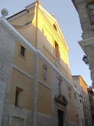 Vista exterior de la iglesia con fachada amarilla y cielo despejado