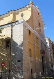 Fachada frontal de la iglesia con detalles en piedra y cielo azul