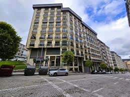 Vista exterior del edificio en la Calle Dalí de Ourense con fachada moderna y plaza adoquinada
