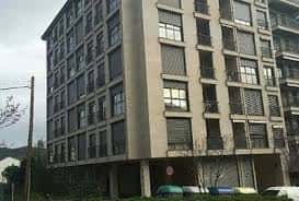 Fachada lateral del edificio en Calle Dalí con balcones y ventanas cerradas