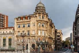 Vista amplia del edificio de la Sociedad Bilbaina desde la calle, con cielo nublado y entorno urbano