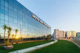 Vista exterior del Hotel Abba Playa Gijón con fachada de cristal al atardecer