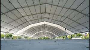 Vista panorámica del interior del recinto con suelo despejado y columnas de soporte bajo techo curvo