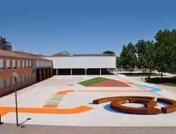 Patio recreativo del colegio con zonas de juego coloridas y áreas verdes